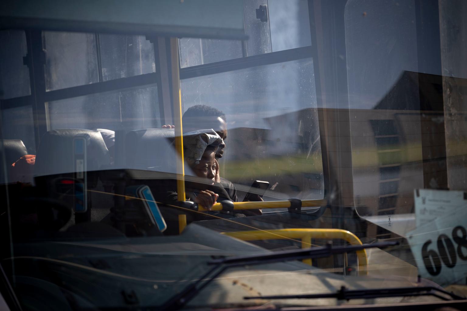 People look out from a bus window 