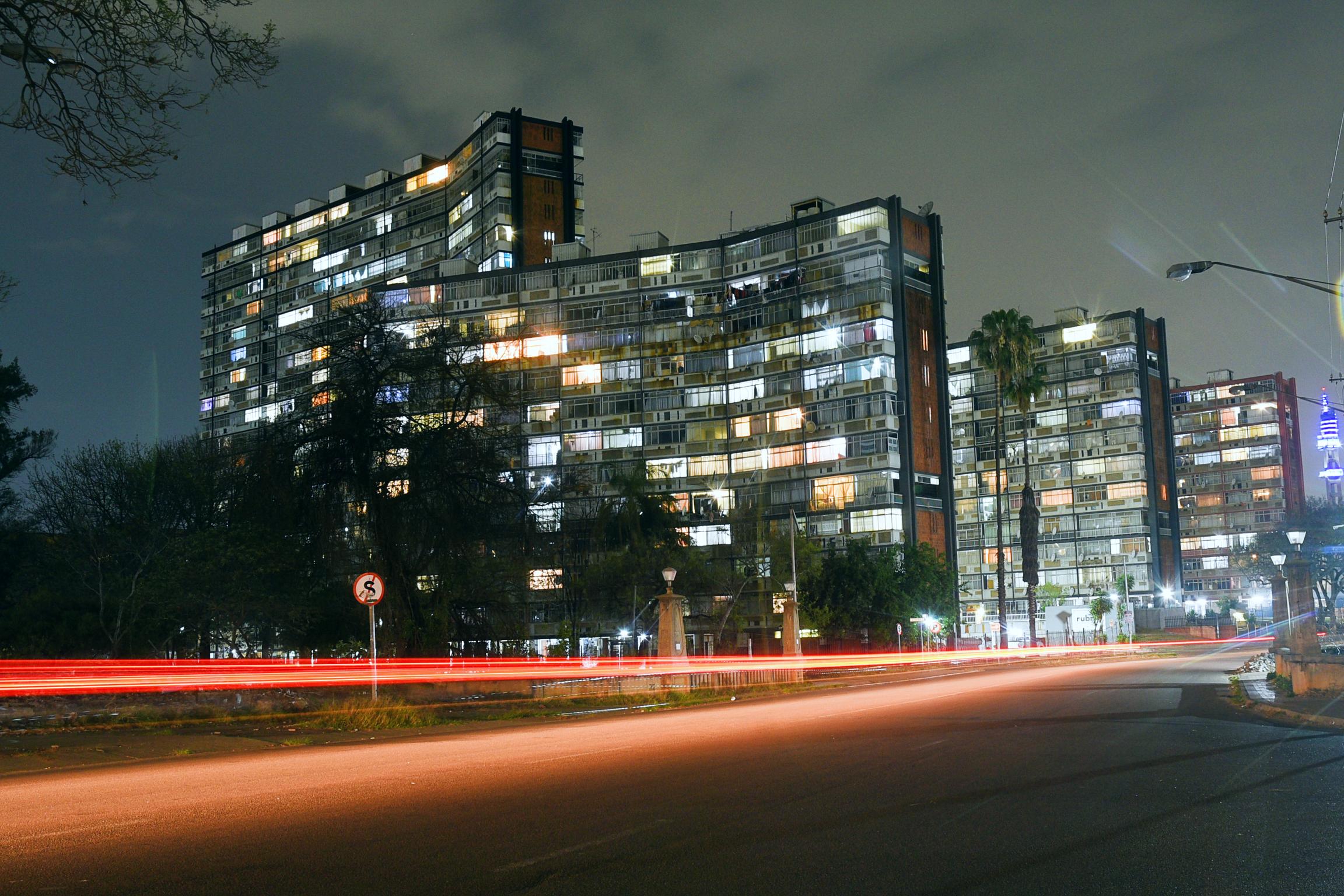 Light Trails and City Lights:  A vibrant shot of Sunnyside at night. The streaks of red and white light from passing cars create a sense of motion, captured through a long exposure. 