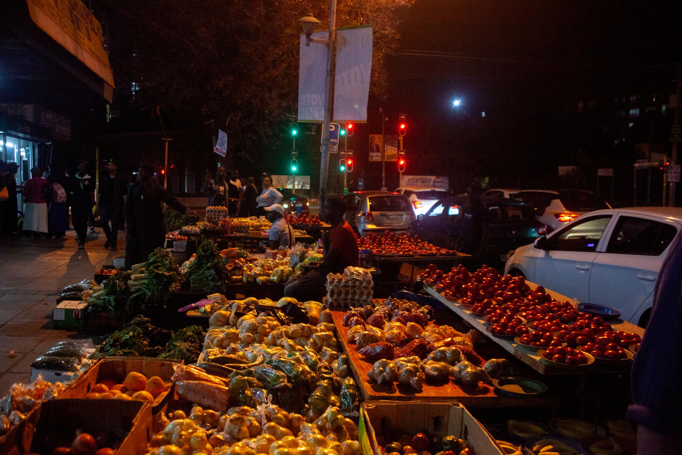 A Bustling Night Market:  Street vendors selling fresh produce