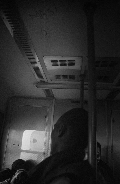The interior ceiling of a train carriage, with a passenger in silhouette below.